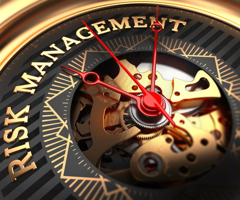 Risk Management on Black-Golden Watch Face with Closeup View of Watch Mechanism.