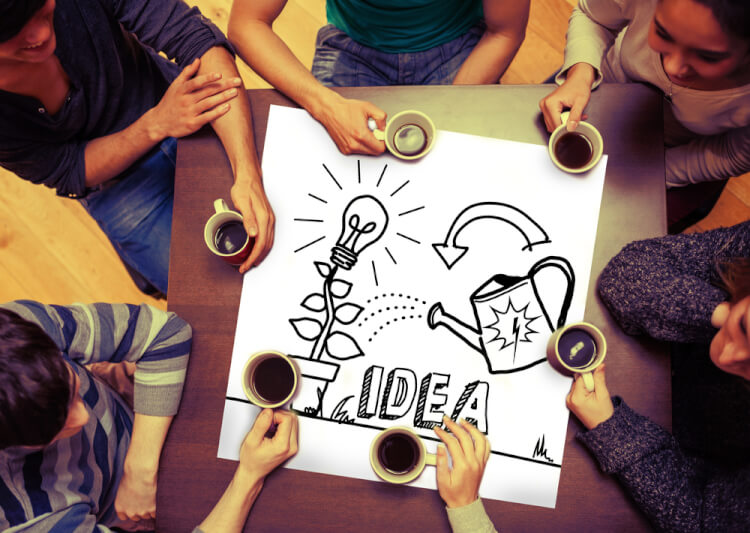 Composite image of idea and innovation graphic on page with people sitting around table drinking coffee