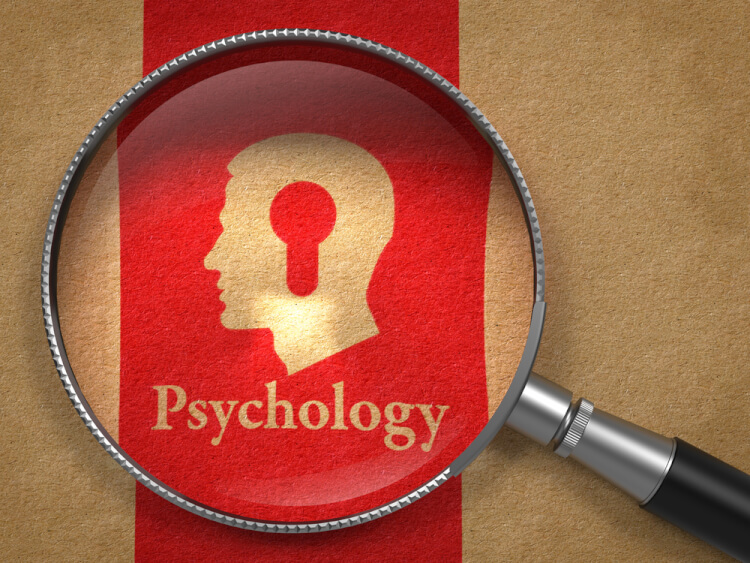 Psychology Concept Magnifying Glass with Word Psychology and Icon of Head with a Keyhole on Old Paper with Red Vertical Line Background.