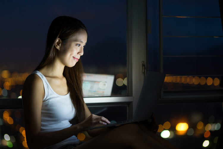 Woman working with laptop computer at night
