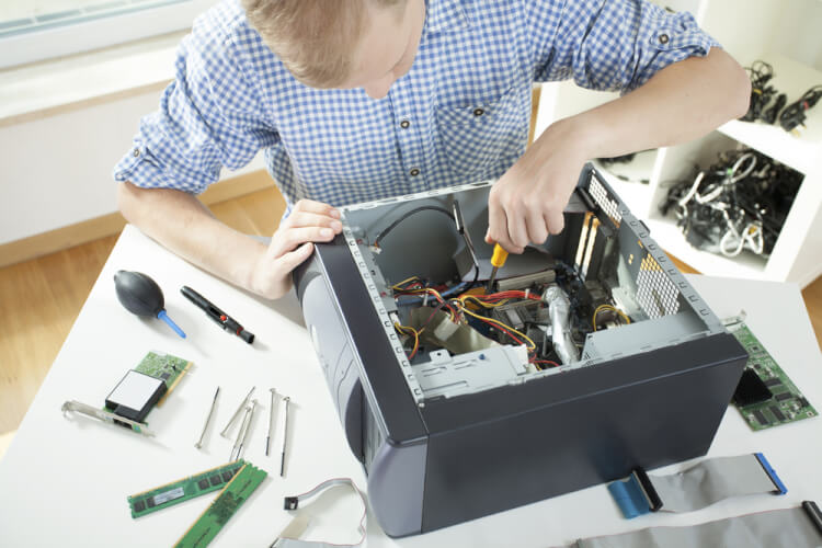 Young man fixing computer on his own